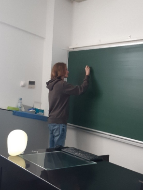 Person writes on a blackboard