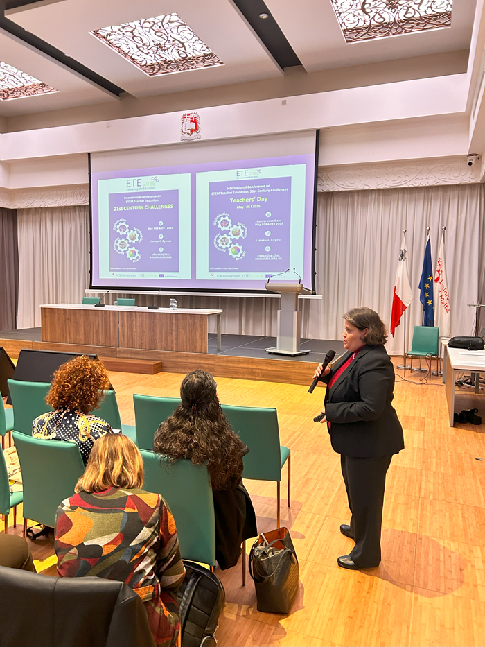 A person gives a presentation on the Educating the Educators converence in an auditorium to an audience.