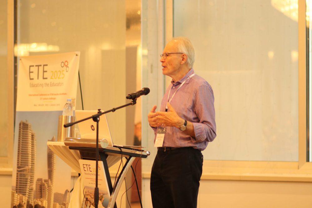 A person is standing in front of an audience, giving a speech. In the background there is a ETE2025 banner.
